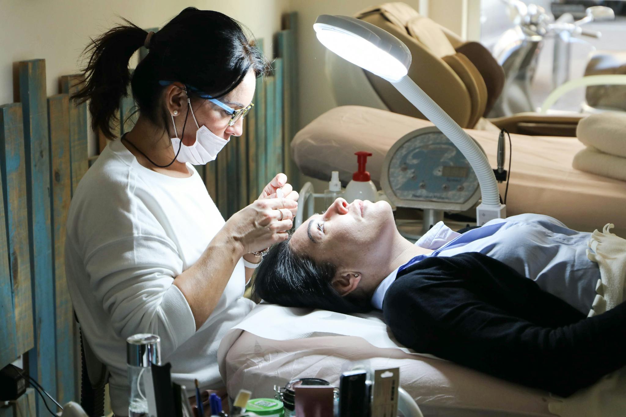 Beautician carefully performs a facial treatment on a woman in a spa setting, ensuring relaxation and care.
